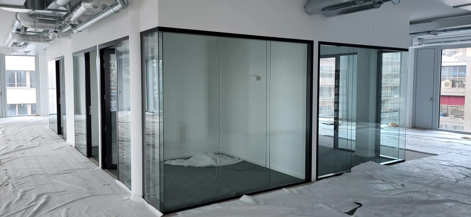 Ganzglas-Eckbüro während des Ausbaus mit Skyline im Hintergrund
