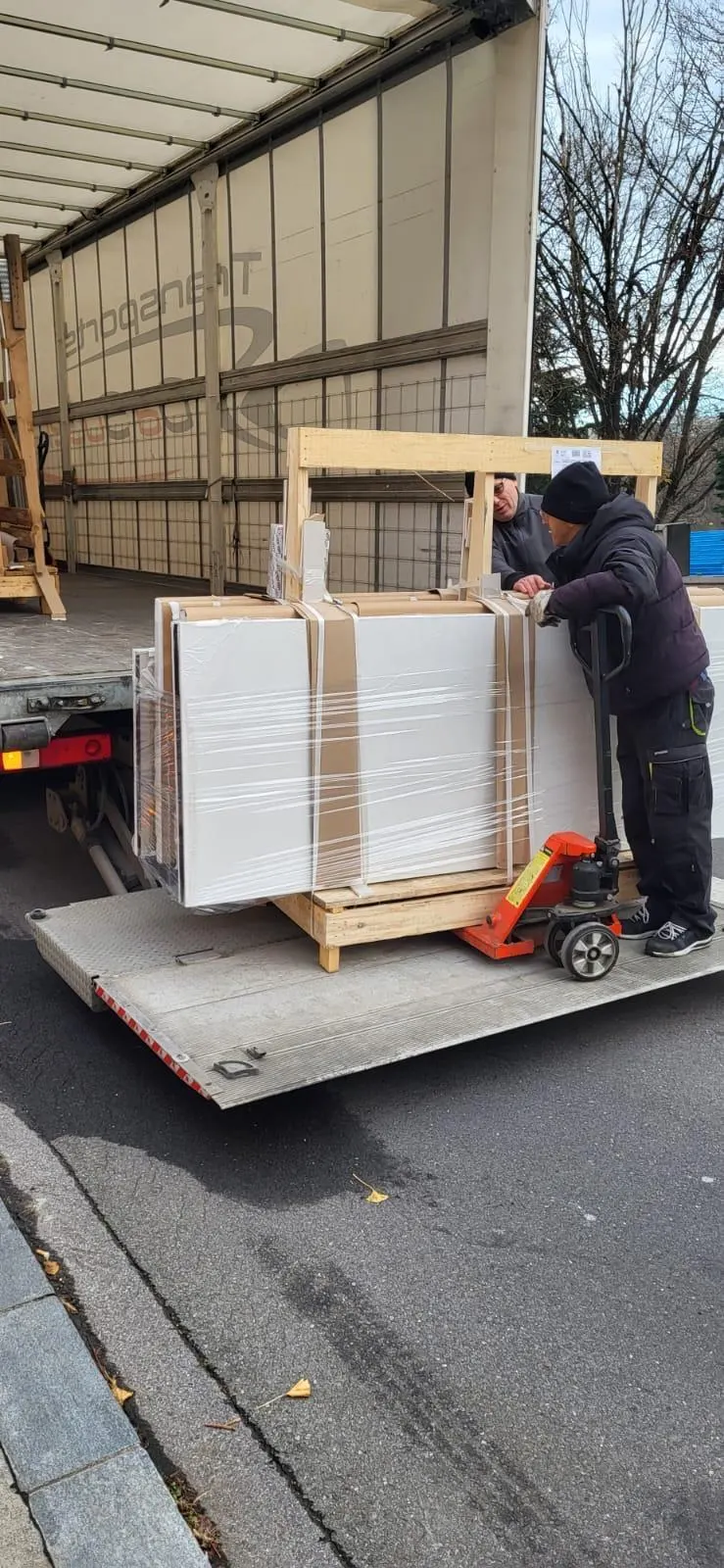Monteur entlädt verpackte Glaselemente vom Lieferwagen