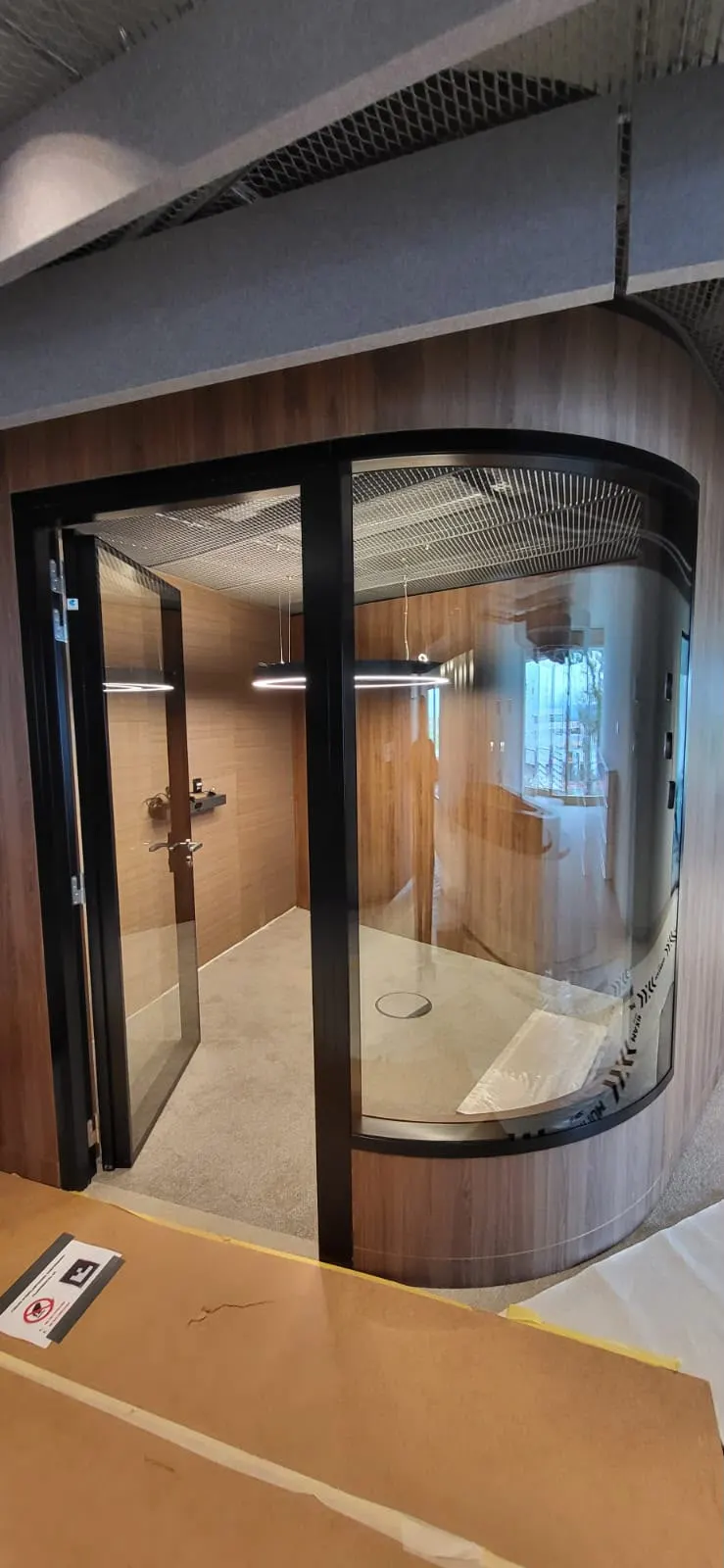 Meetingbox mit gebogenem Glas, Holzverkleidung und Akustikdecke