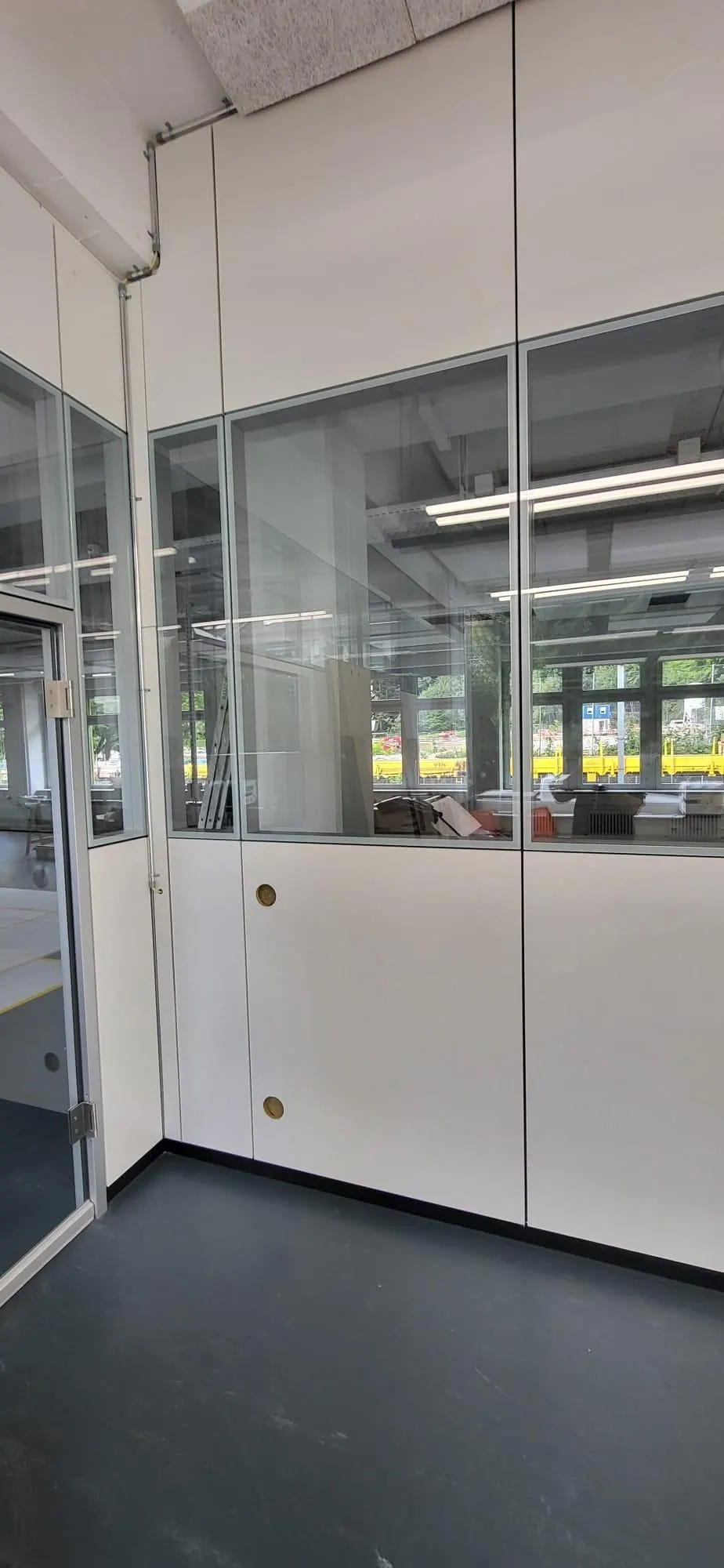 Vollwand mit Glasaufsatz in einem Büro mit dunklem Boden