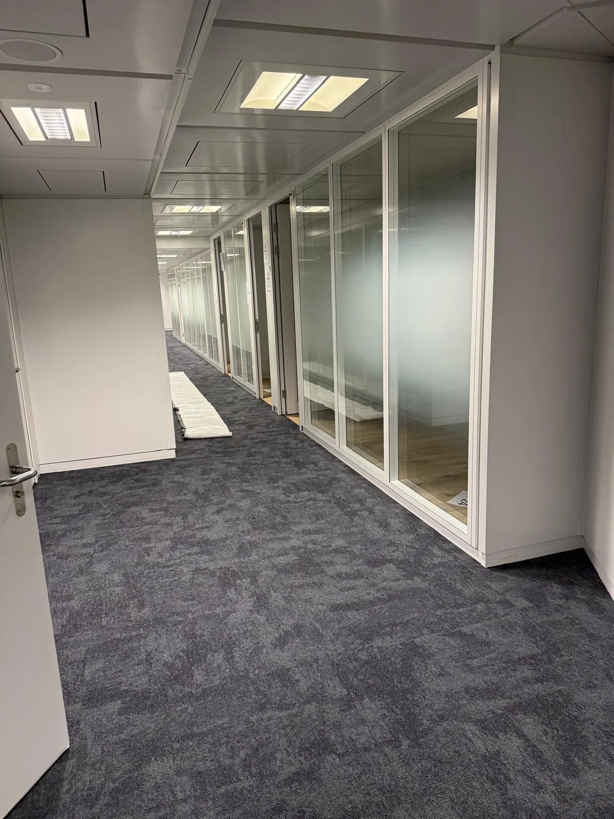 Korridor mit Systemtrennwand und durchgehender Glasfront, Hochformat