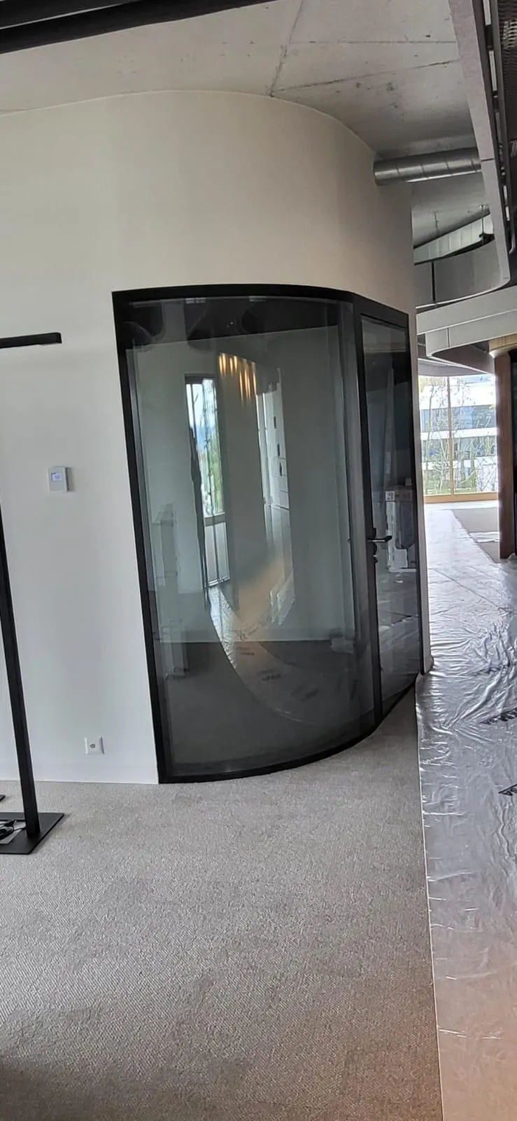 Freistehende Telefonbox mit Rauchglas mitten im Raum